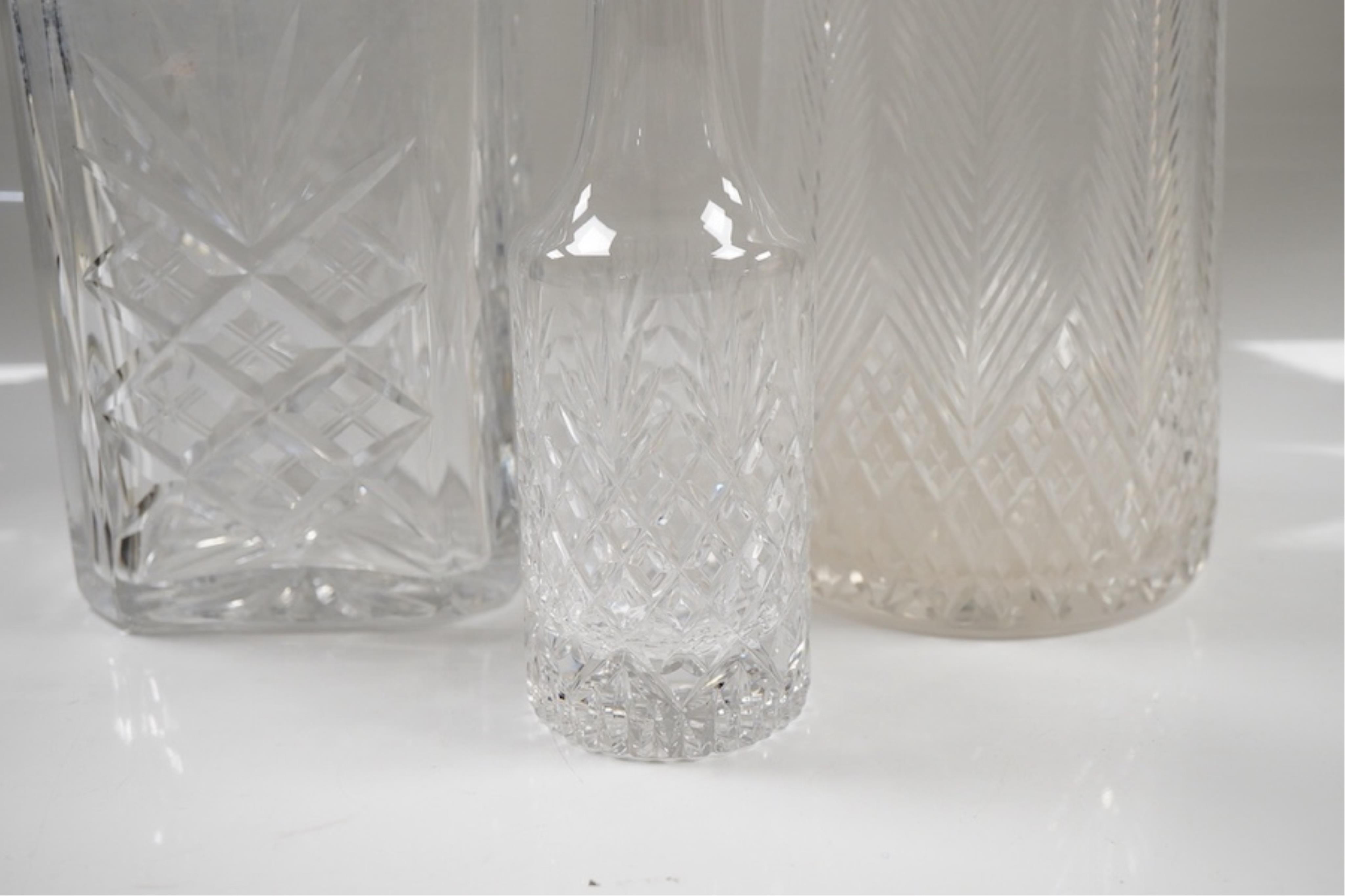 Three assorted silver mounted cut glass decanters, including two modern and one earlier with lock, marks rubbed, no key, the latter 34.1cm.